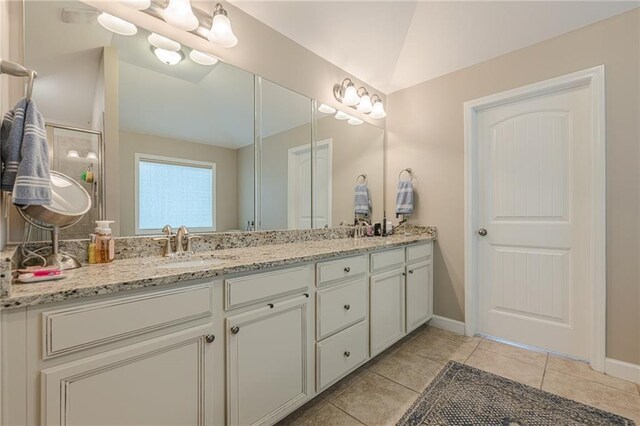 5515 Cheatam Ave, Cumming, GA 30040 - bathroom featuring double vanity, tile patterned floors, a shower stall, and vaulted ceiling