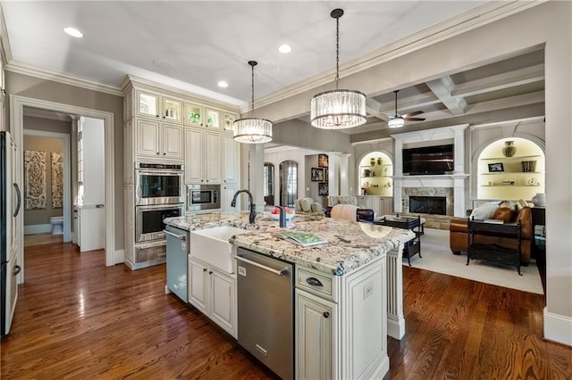 341 Carl Sanders Dr, Acworth, GA 30101 - kitchen featuring appliances with stainless steel finishes, a fireplace, ceiling fan, ornamental molding, and light stone countertops