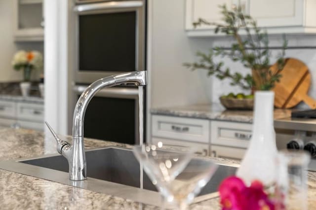 details with white cabinetry and sink