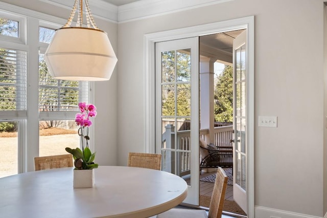 dining space with ornamental molding and a healthy amount of sunlight