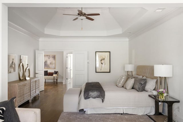 bedroom with ceiling fan, ornamental molding, a tray ceiling, and dark hardwood / wood-style flooring