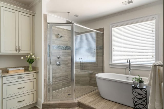 bathroom with ornamental molding, shower with separate bathtub, and a wealth of natural light