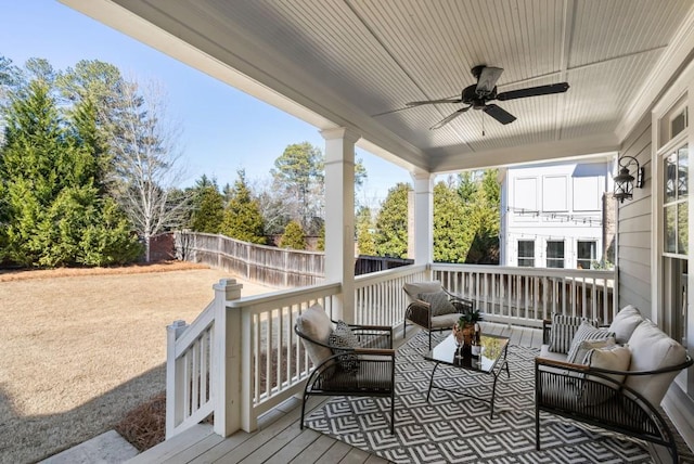 wooden deck featuring an outdoor living space and ceiling fan