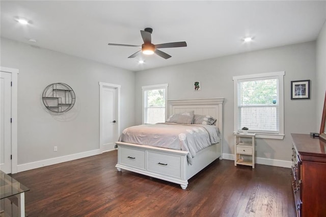 bedroom with ceiling fan, dark hardwood / wood-style flooring, and multiple windows