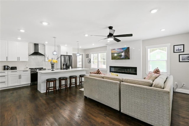 living room featuring dark wood-type flooring and ceiling fan