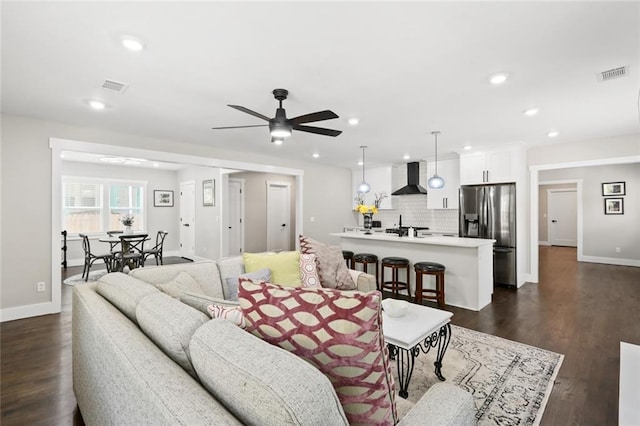 living room with ceiling fan, dark hardwood / wood-style floors, and sink