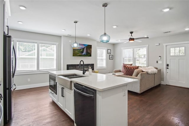 kitchen featuring a kitchen island with sink, hanging light fixtures, dark hardwood / wood-style floors, black dishwasher, and white cabinets