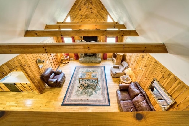 interior space featuring hardwood / wood-style floors, beam ceiling, wooden walls, and high vaulted ceiling