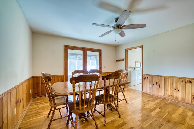 dining area with washer / dryer, wood walls, light wood-type flooring, and ceiling fan