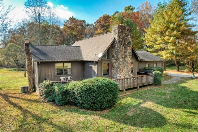 view of home's exterior featuring central air condition unit, a deck, and a lawn