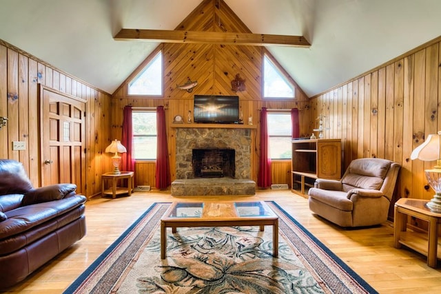 living room featuring high vaulted ceiling, light wood-type flooring, beamed ceiling, a fireplace, and wooden walls