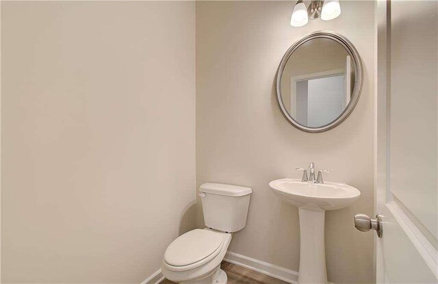 bathroom with wood-type flooring and toilet