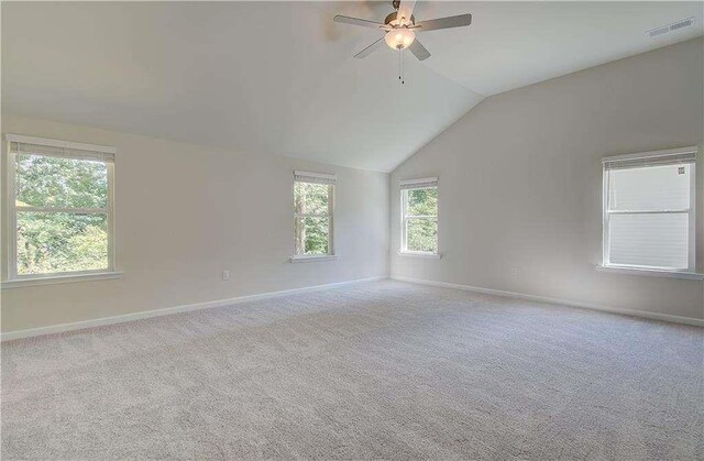 carpeted empty room with vaulted ceiling and ceiling fan