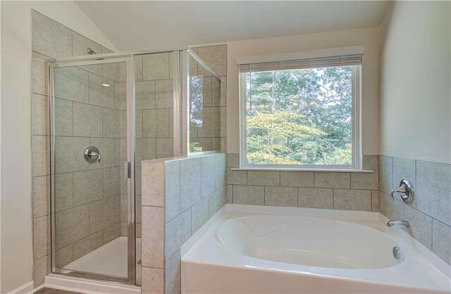 bathroom featuring plus walk in shower and vaulted ceiling