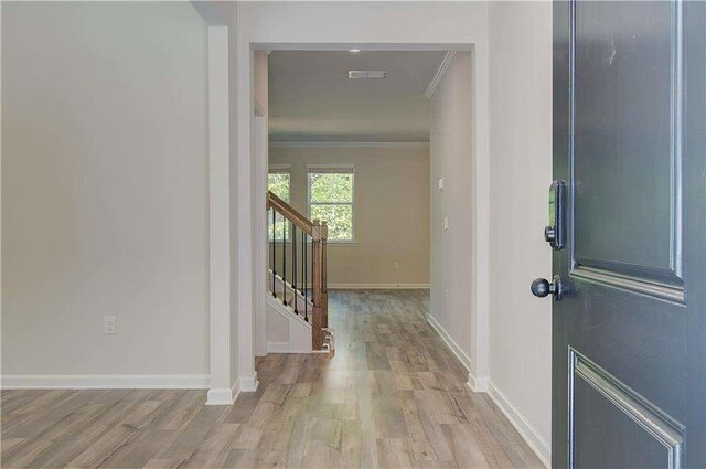 entrance foyer with light wood-type flooring and crown molding