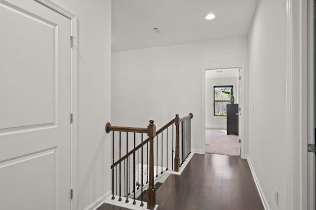 hall featuring dark wood-style flooring, recessed lighting, an upstairs landing, and baseboards