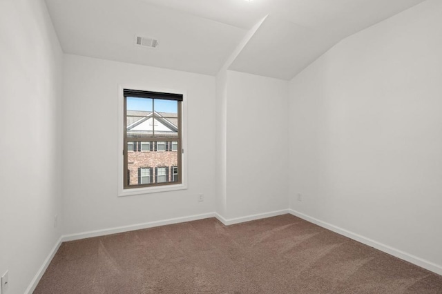 carpeted empty room featuring lofted ceiling, baseboards, and visible vents