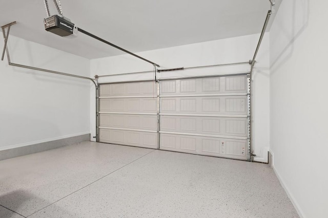 garage with baseboards and a garage door opener