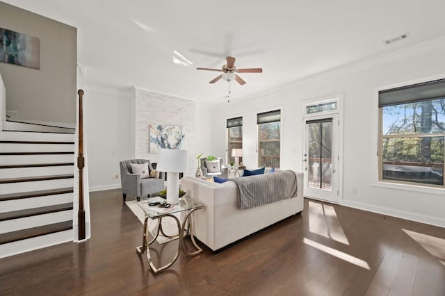 living room with ornamental molding, stairway, baseboards, and wood finished floors