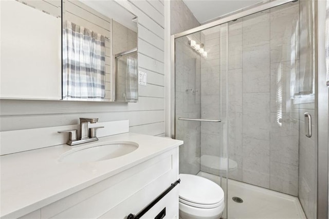 bathroom with vanity, a shower with shower door, and toilet