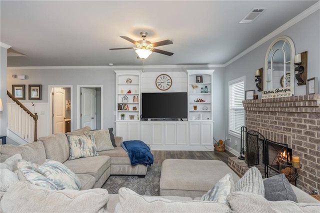48 Violet Ln, Dallas, GA 30132 - living area featuring a fireplace, stairway, ceiling fan, dark wood-type flooring, and ornamental molding