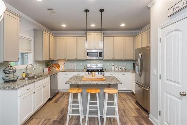 48 Violet Ln, Dallas, GA 30132 - kitchen with appliances with stainless steel finishes, a sink, dark wood-style flooring, a center island, and crown molding