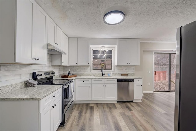 kitchen featuring white cabinets, sink, stainless steel appliances, and light hardwood / wood-style floors