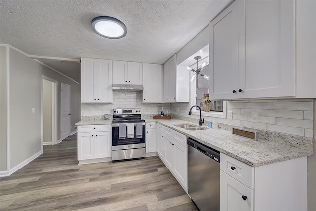 kitchen featuring appliances with stainless steel finishes, white cabinetry, sink, and light hardwood / wood-style flooring