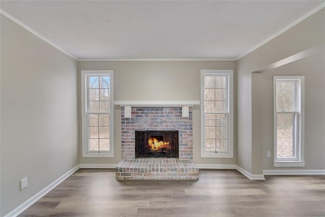 unfurnished living room featuring a fireplace, crown molding, and hardwood / wood-style flooring