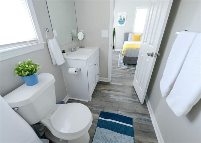 554 Holderness St SW, Atlanta, GA 30310 - bathroom featuring vanity, toilet, baseboards, connected bathroom, and wood finished floors
