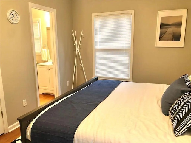 554 Holderness St SW, Atlanta, GA 30310 - bedroom featuring ensuite bathroom, baseboards, and wood finished floors