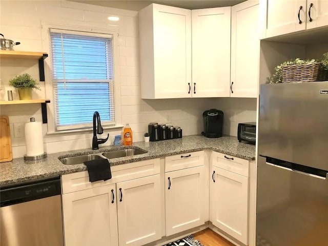 554 Holderness St SW, Atlanta, GA 30310 - kitchen with stainless steel appliances, decorative backsplash, a sink, white cabinets, and light stone countertops