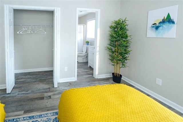 554 Holderness St SW, Atlanta, GA 30310 - unfurnished bedroom featuring baseboards, connected bathroom, wood finished floors, and a closet