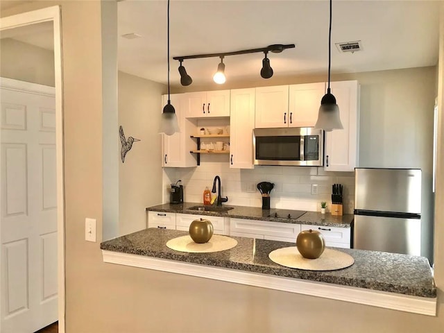 554 Holderness St SW, Atlanta, GA 30310 - kitchen featuring white cabinets, stainless steel appliances, tasteful backsplash, a sink, and decorative light fixtures