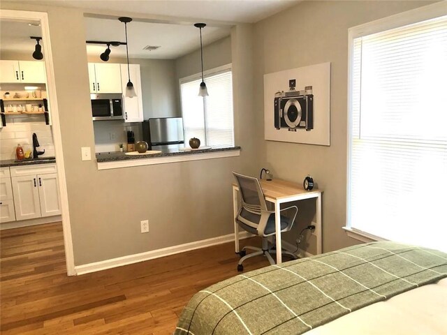 554 Holderness St SW, Atlanta, GA 30310 - bedroom featuring a sink, freestanding refrigerator, wood finished floors, baseboards, and visible vents
