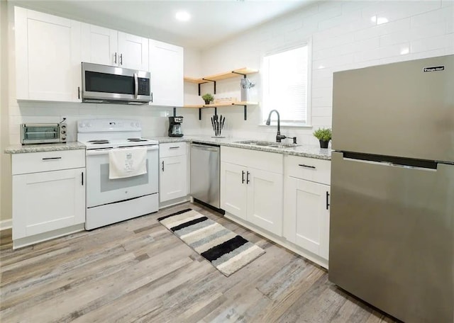 554 Holderness St SW, Atlanta, GA 30310 - kitchen with light wood-style flooring, white cabinets, a sink, and appliances with stainless steel finishes