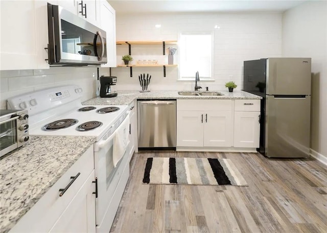 554 Holderness St SW, Atlanta, GA 30310 - kitchen featuring a sink, white cabinetry, tasteful backsplash, light wood-style flooring, and stainless steel appliances