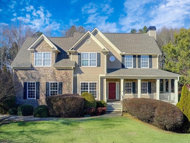 view of front of house featuring covered porch and a front yard