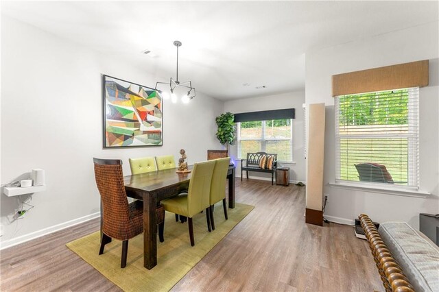 dining space with wood-type flooring and a chandelier