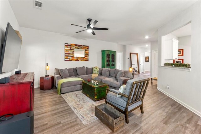 living room featuring ceiling fan and light hardwood / wood-style flooring