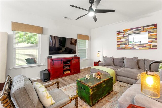 living room with light wood-type flooring and ceiling fan