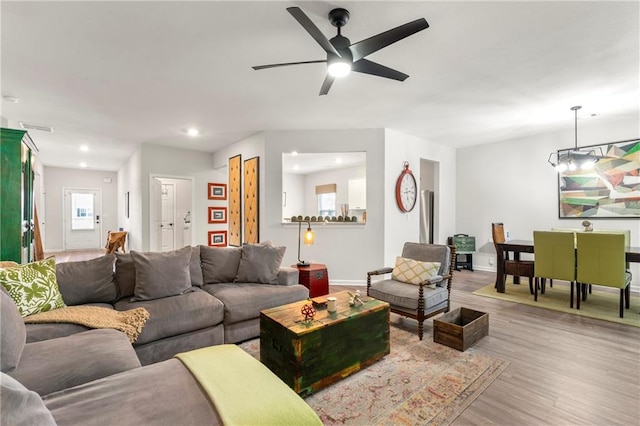 living room with light wood-type flooring and ceiling fan