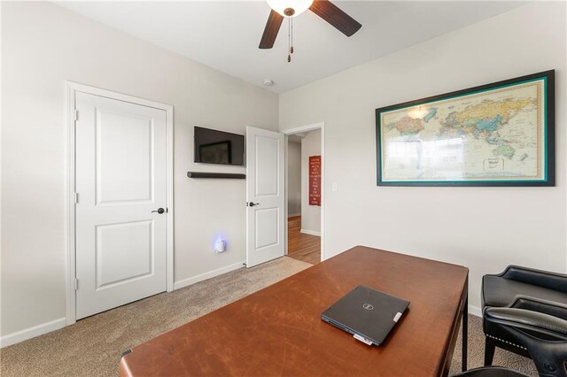 carpeted office space featuring ceiling fan