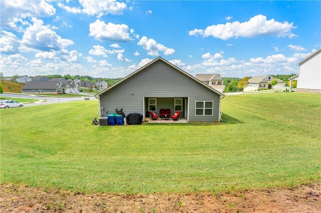 rear view of property featuring central AC unit, a yard, and a patio area