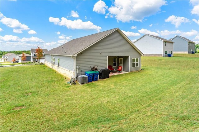 back of house with a lawn and central air condition unit