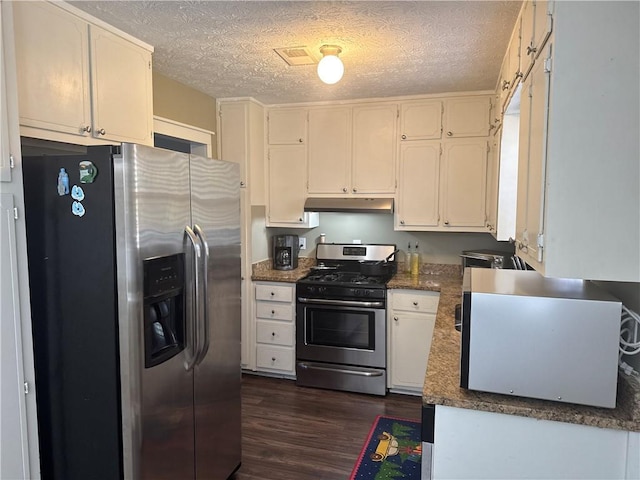 2943 E Howell Dr, Lawrenceville, GA 30044 - kitchen with dark wood finished floors, under cabinet range hood, appliances with stainless steel finishes, and a textured ceiling