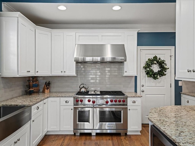 kitchen featuring white cabinetry, double oven range, hardwood / wood-style floors, range hood, and light stone countertops