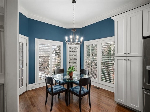 dining space with ornamental molding, dark hardwood / wood-style floors, and a chandelier