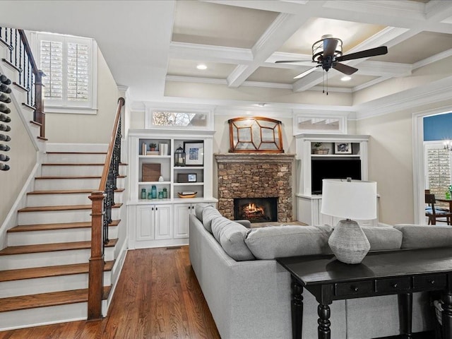 living room featuring dark wood-type flooring, ceiling fan, coffered ceiling, a fireplace, and beamed ceiling