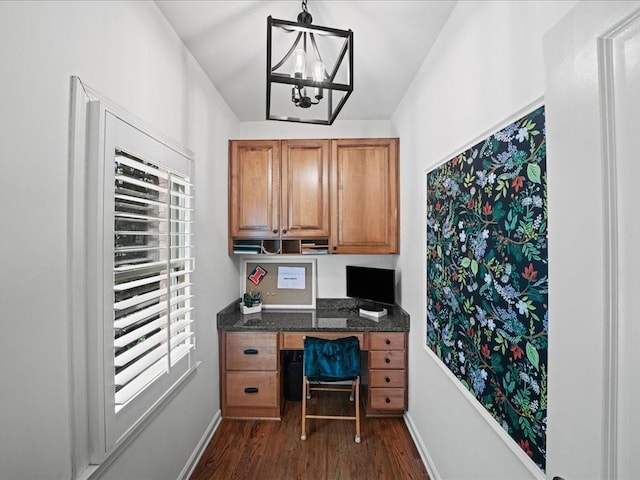 office with dark hardwood / wood-style floors, built in desk, and a notable chandelier